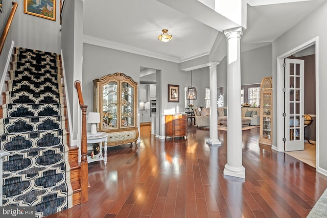 foyer featuring ornamental molding, ornate columns, and hardwood / wood-style floors