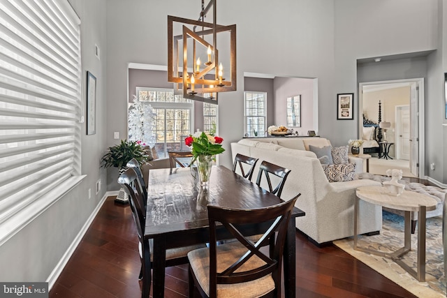 dining room with an inviting chandelier, dark hardwood / wood-style flooring, and a high ceiling