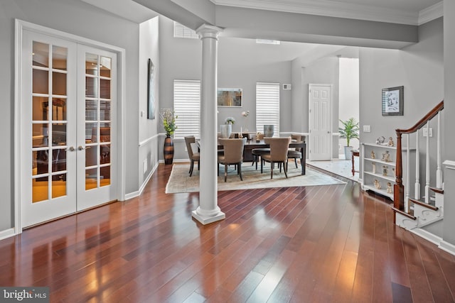 foyer with crown molding, ornate columns, french doors, and dark hardwood / wood-style floors