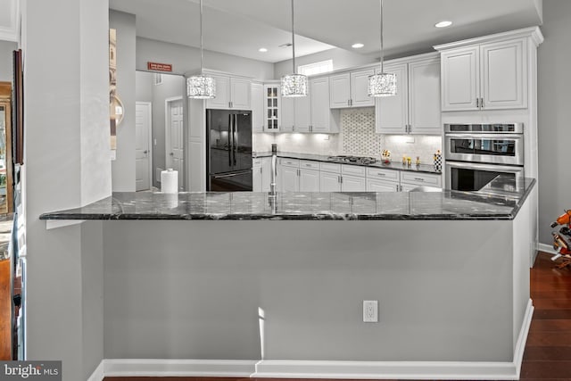 kitchen featuring tasteful backsplash, stainless steel appliances, white cabinets, pendant lighting, and kitchen peninsula