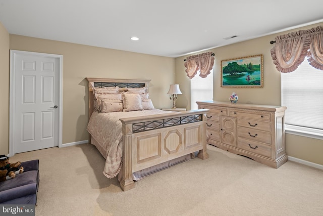 bedroom with multiple windows and light colored carpet