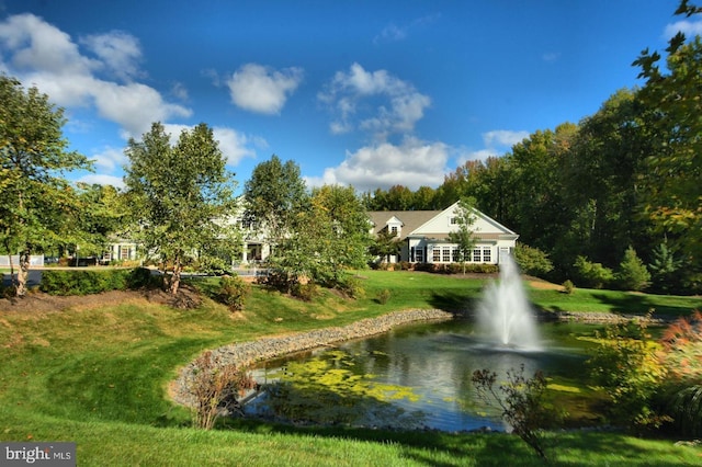 view of community with a lawn and a water view