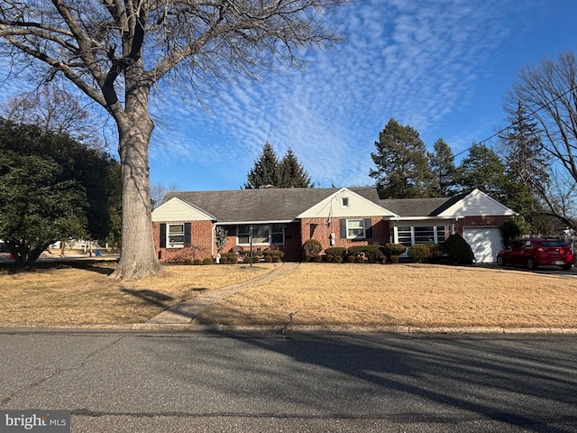 view of front of property featuring an attached garage and brick siding