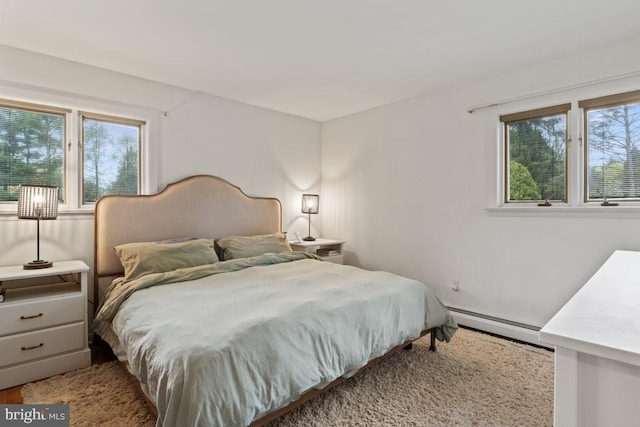 bedroom featuring multiple windows and a baseboard radiator