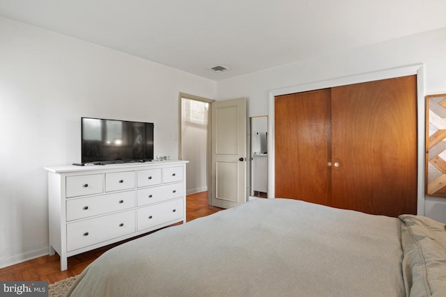 bedroom with parquet flooring and a closet