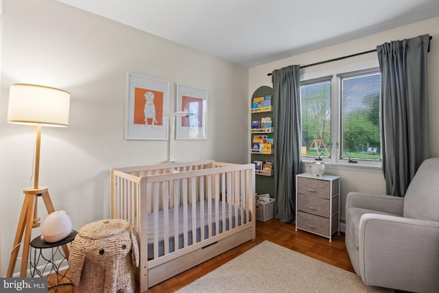 bedroom with a crib and parquet flooring