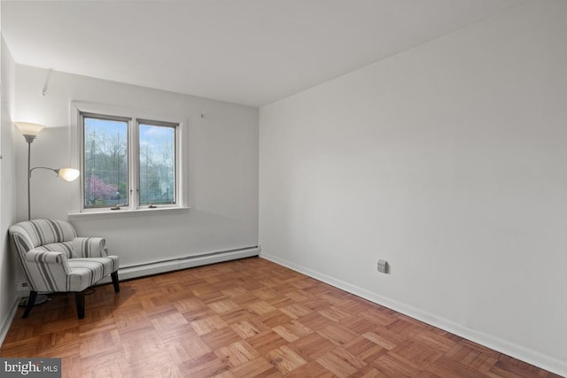 unfurnished room with baseboard heating and light parquet floors