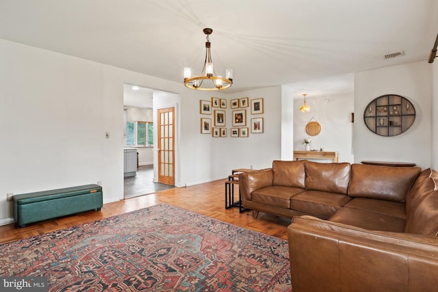 living room with parquet floors and an inviting chandelier