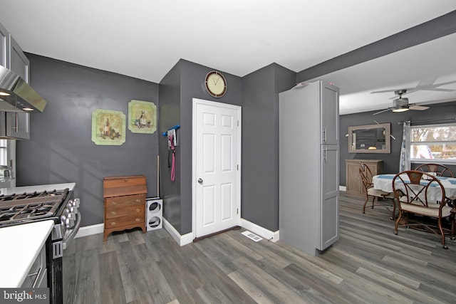 kitchen featuring light countertops, dark wood-type flooring, stainless steel gas range, and gray cabinets