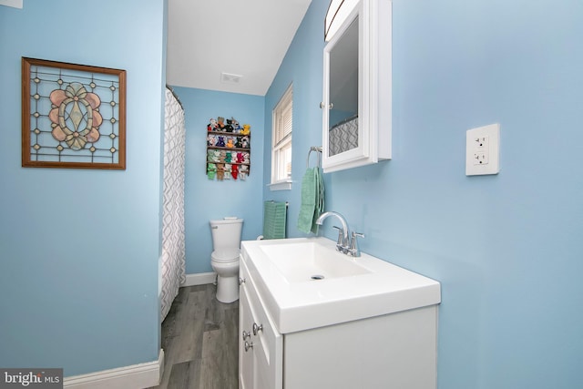 full bathroom with toilet, wood finished floors, visible vents, vanity, and baseboards