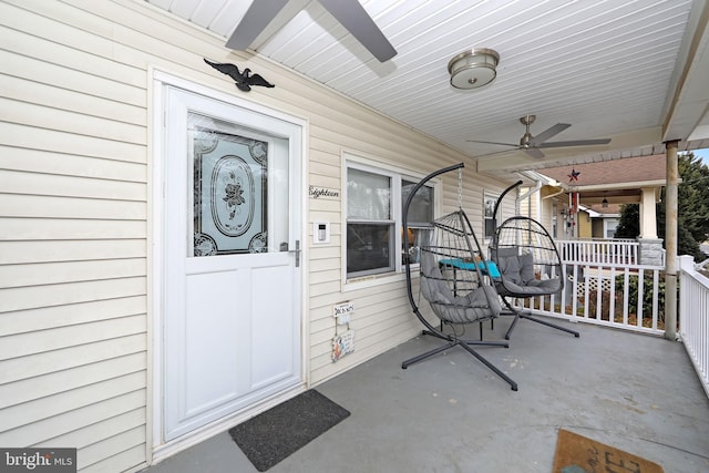 entrance to property with a porch and a ceiling fan