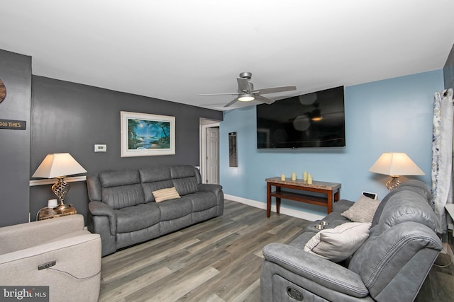 living room featuring ceiling fan, wood finished floors, and baseboards