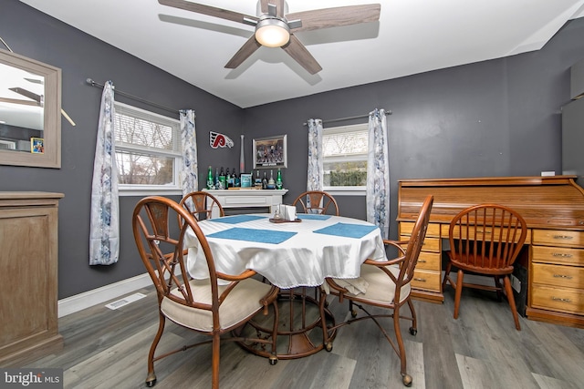 dining space featuring a ceiling fan, light wood-type flooring, visible vents, and baseboards