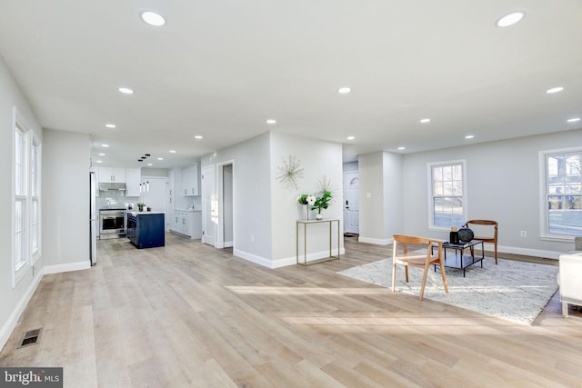 interior space featuring light wood-type flooring, baseboards, and recessed lighting