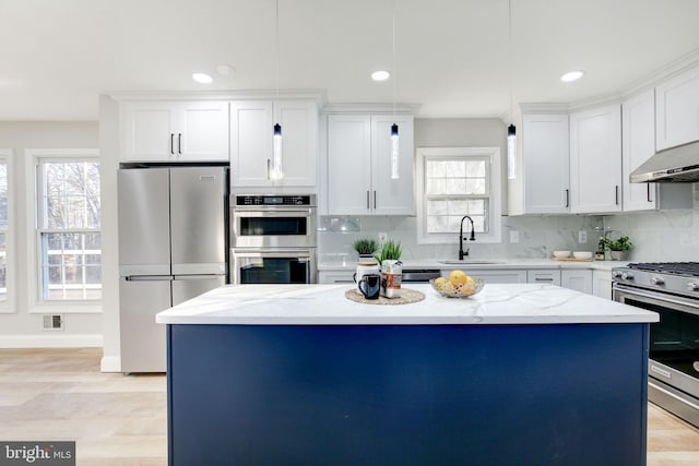 kitchen featuring appliances with stainless steel finishes, a kitchen island, a sink, and decorative backsplash