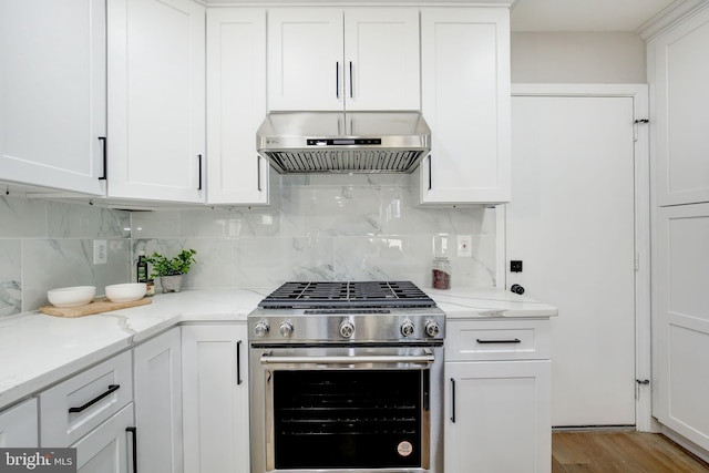 kitchen featuring backsplash, light wood-style floors, white cabinetry, high end stove, and under cabinet range hood