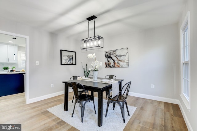 dining space featuring baseboards and light wood finished floors