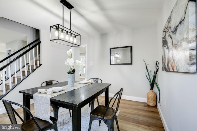 dining space featuring stairs, baseboards, and wood finished floors