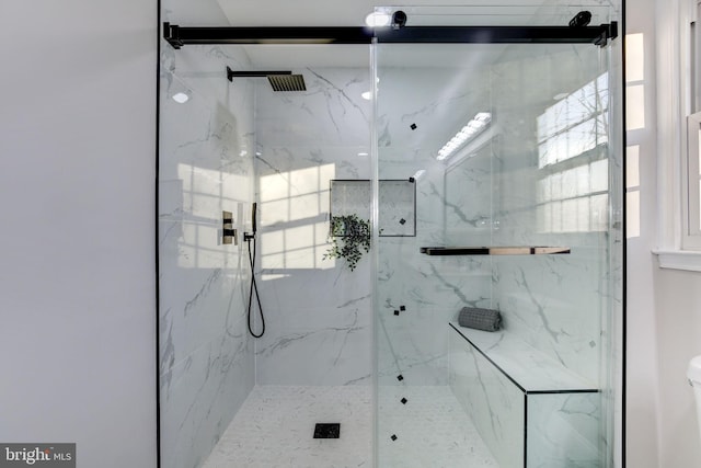 bathroom with a marble finish shower and a wealth of natural light