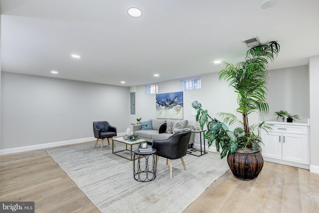 living room featuring light wood-style floors, recessed lighting, visible vents, and baseboards