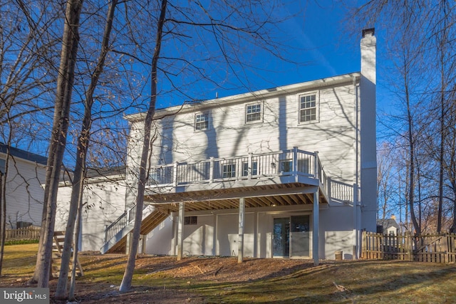 rear view of house with stairway, a chimney, fence, and a wooden deck