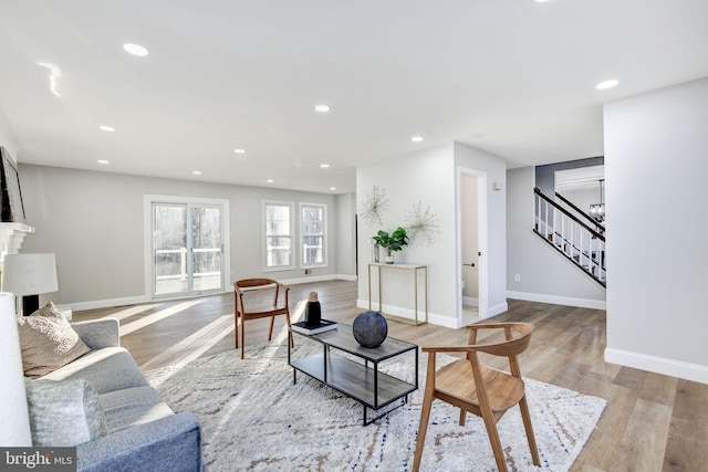 living room with recessed lighting, a fireplace, wood finished floors, baseboards, and stairway