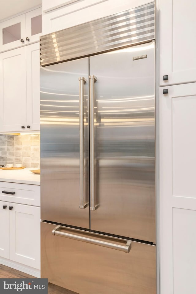 kitchen with white cabinetry, decorative backsplash, and stainless steel built in fridge