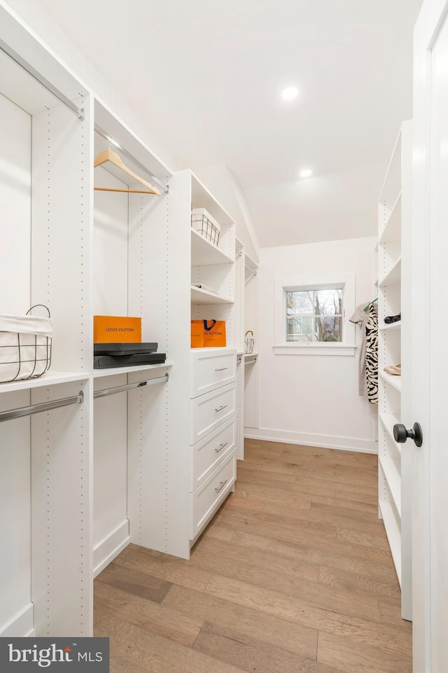 spacious closet featuring vaulted ceiling and light hardwood / wood-style flooring