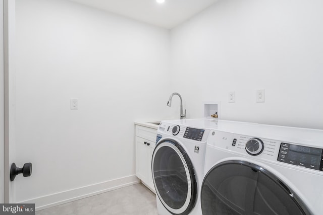 washroom with sink, cabinets, and washing machine and clothes dryer