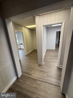 hall with baseboards and wood finished floors