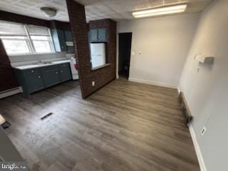 kitchen featuring baseboards, light countertops, and dark wood-type flooring