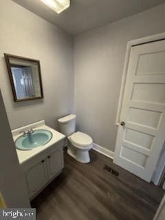 bathroom with vanity, wood finished floors, toilet, and baseboards