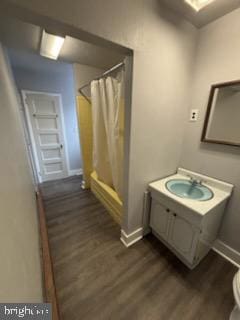 full bath with curtained shower, vanity, baseboards, and wood finished floors