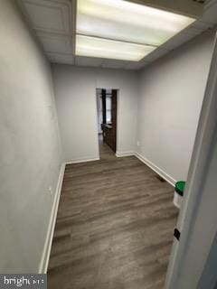 empty room featuring baseboards and dark wood finished floors