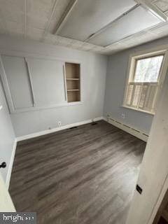 unfurnished room with dark wood-style flooring, built in features, and baseboards