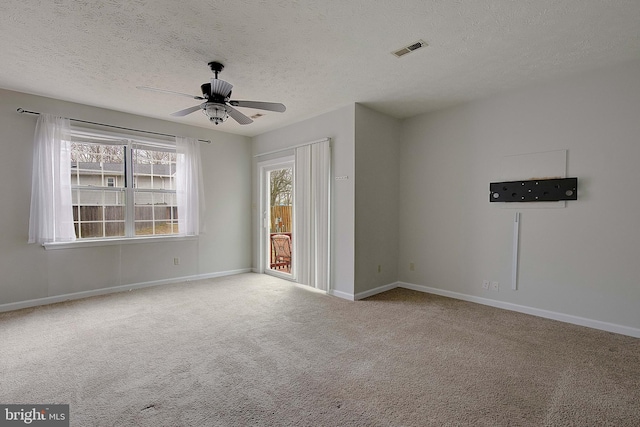 empty room with baseboards, a textured ceiling, visible vents, and light colored carpet