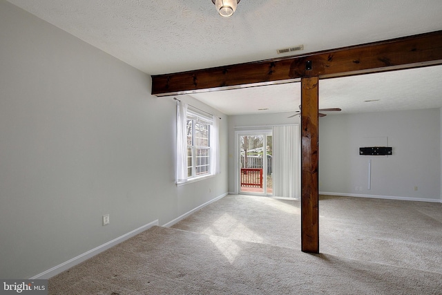 unfurnished room featuring light carpet, a textured ceiling, and baseboards