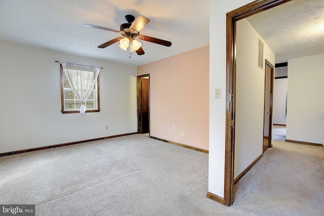 unfurnished room with visible vents, light colored carpet, and a textured ceiling