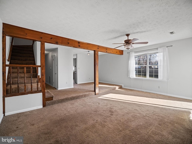 unfurnished room featuring carpet floors, visible vents, stairway, a textured ceiling, and baseboards