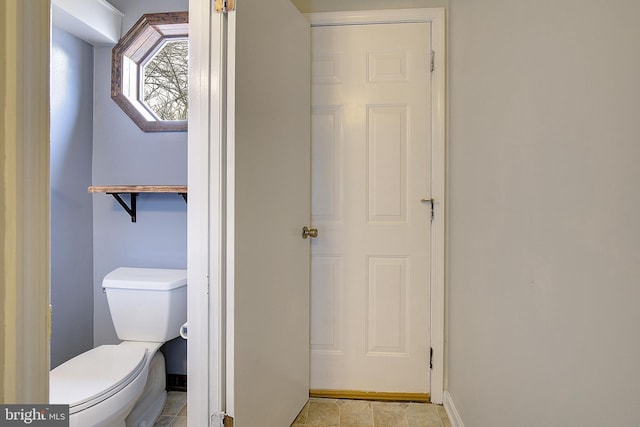 bathroom featuring toilet and baseboards