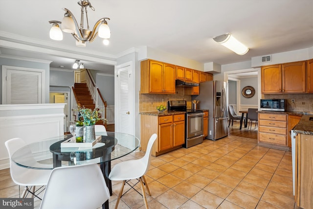 kitchen with stainless steel appliances, visible vents, hanging light fixtures, dark stone counters, and under cabinet range hood