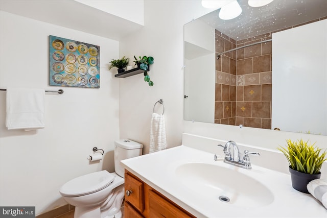 bathroom featuring a shower, vanity, and toilet