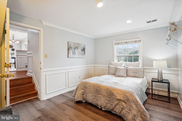 bedroom featuring a wainscoted wall, crown molding, recessed lighting, visible vents, and wood finished floors