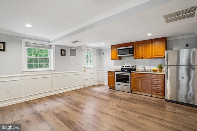 kitchen featuring light countertops, visible vents, appliances with stainless steel finishes, ornamental molding, and plenty of natural light