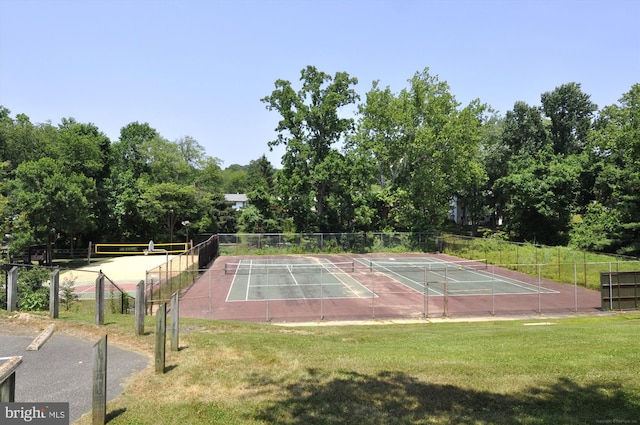 view of sport court featuring fence and a lawn