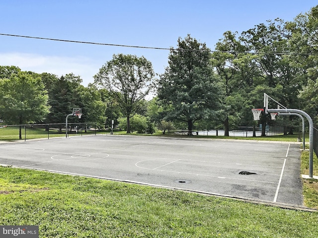 view of basketball court featuring a yard, community basketball court, and fence