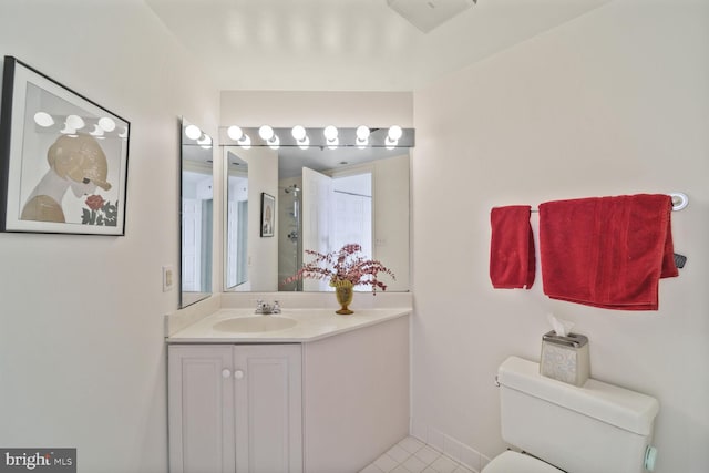 bathroom featuring tile patterned flooring, vanity, toilet, and baseboards