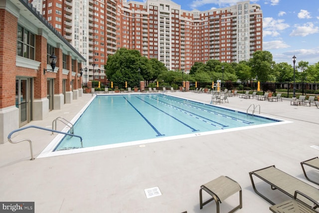 community pool with fence and a patio