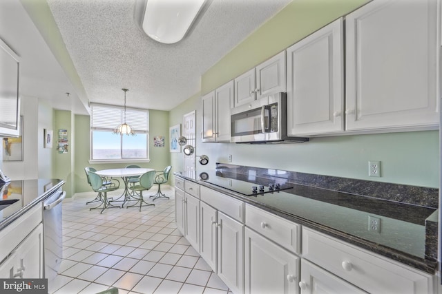 kitchen featuring stainless steel appliances, white cabinets, a textured ceiling, and light tile patterned flooring