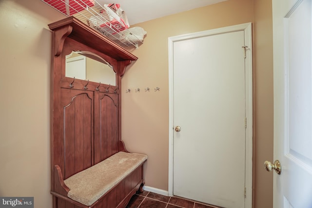 mudroom with dark tile patterned floors